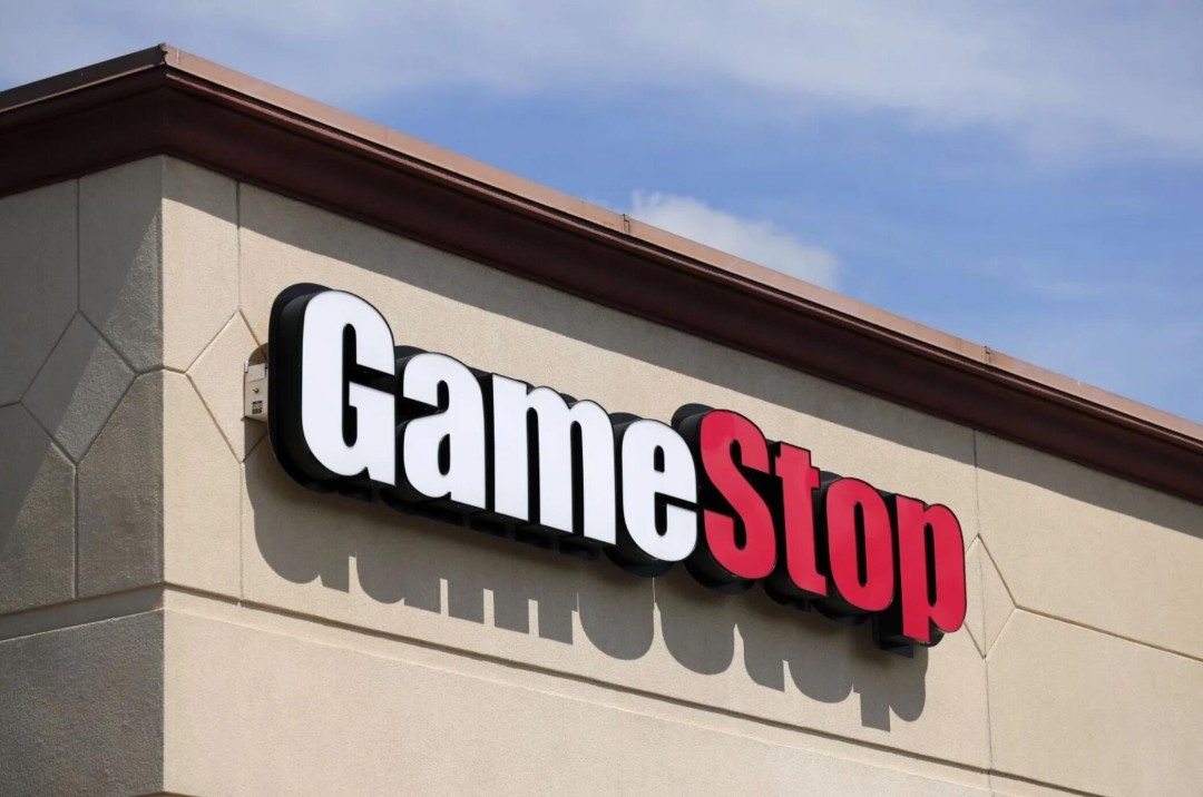 GameStop门店内景,货架上摆满电子游戏和收藏品,暗示实体游戏销售转型