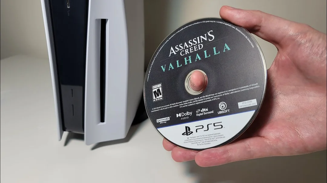PS5主机与实体光盘并置,背景是数字下载符号,象征实体与数字游戏的冲突
